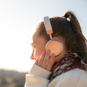 profile of woman with hand on headphones